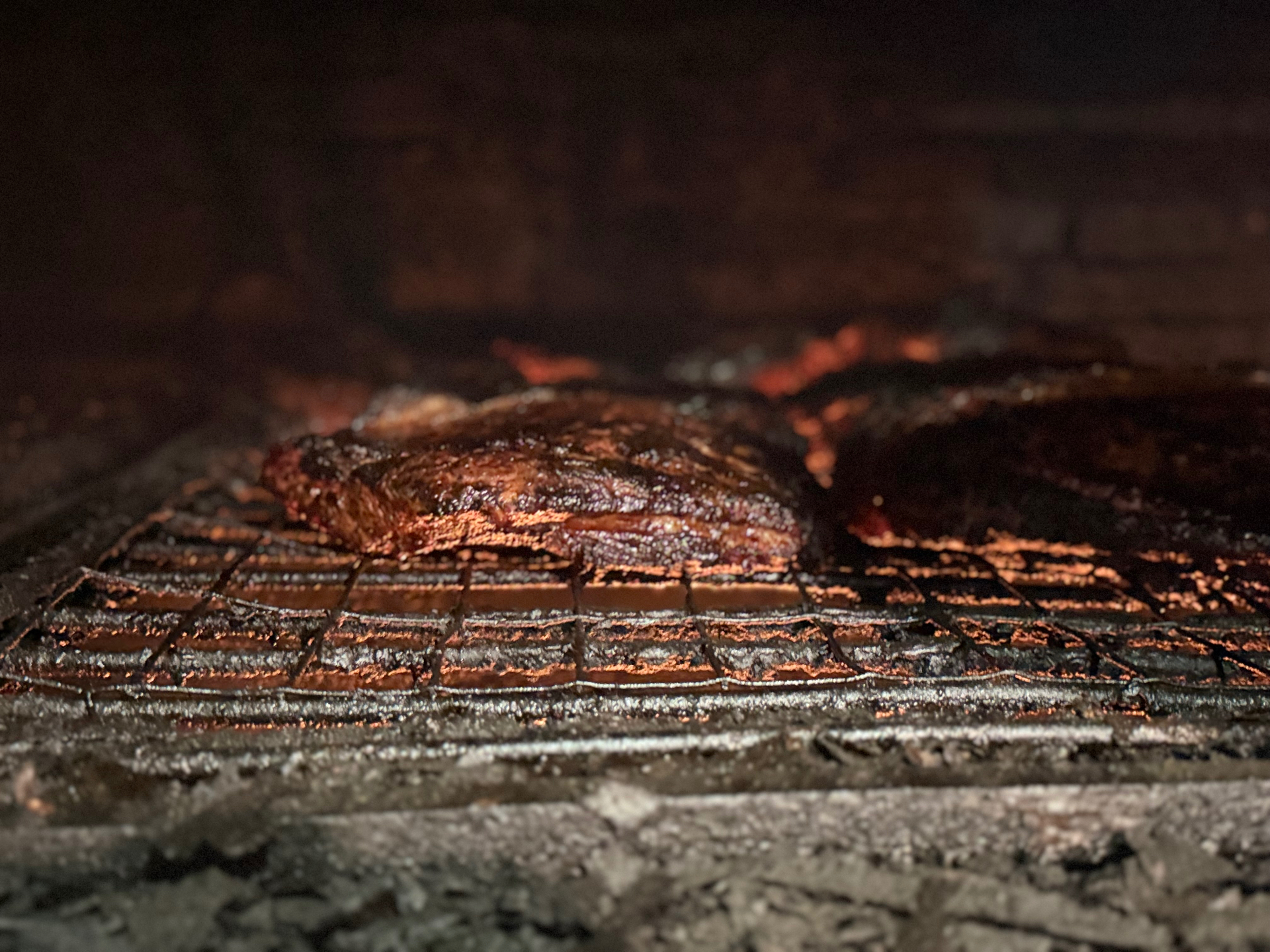Brisket glowing over coals